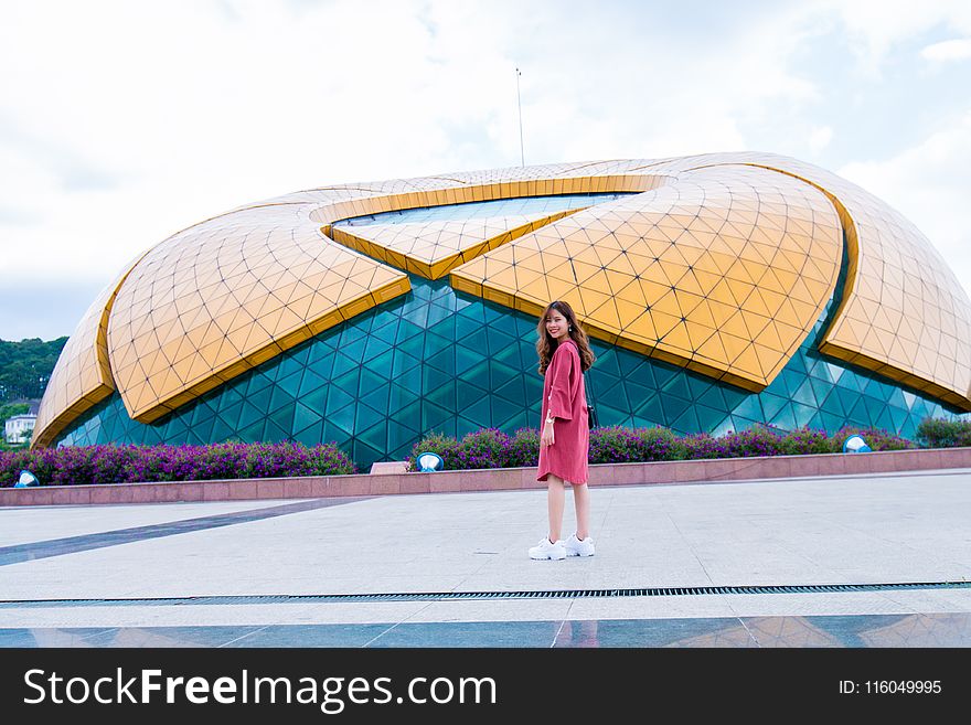 Woman Standing In Front Of Yellow And Blue Glass Building