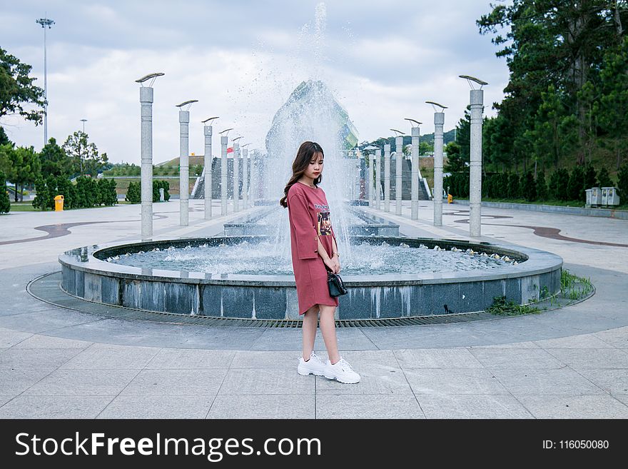 Woman Wearing Pink Crew-neck Long-sleeved Midi Dress Standing Concrete Outdoor Fountain