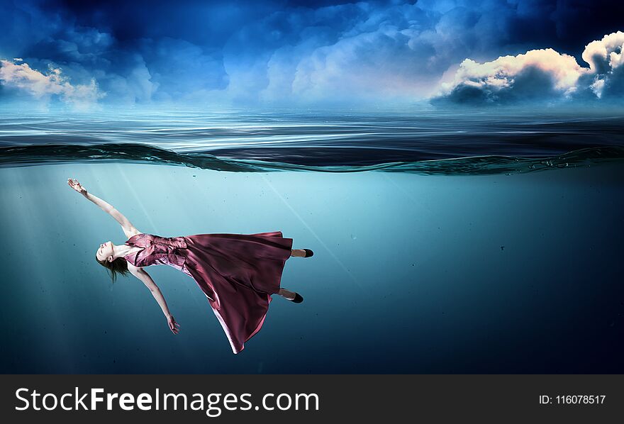 Young beautiful woman in red dress underwater. Young beautiful woman in red dress underwater