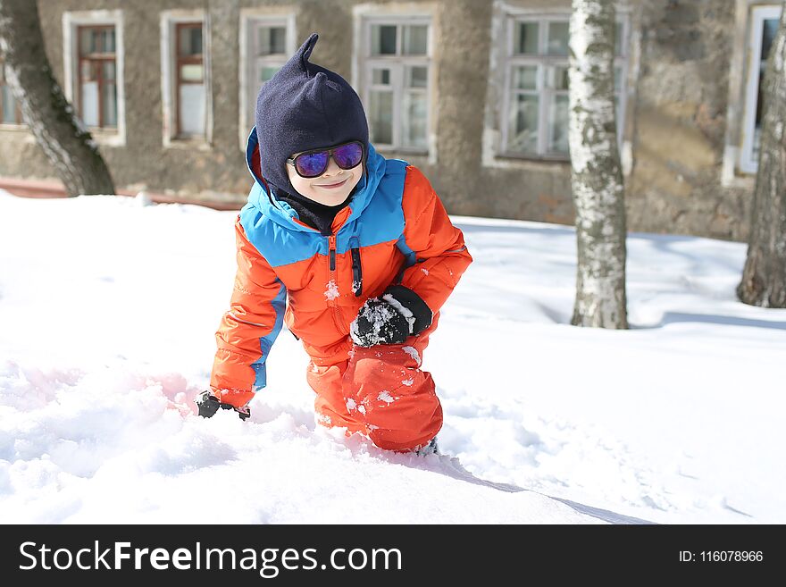 5 years little boy in warm ski suit playing outdoors in winter. 5 years little boy in warm ski suit playing outdoors in winter