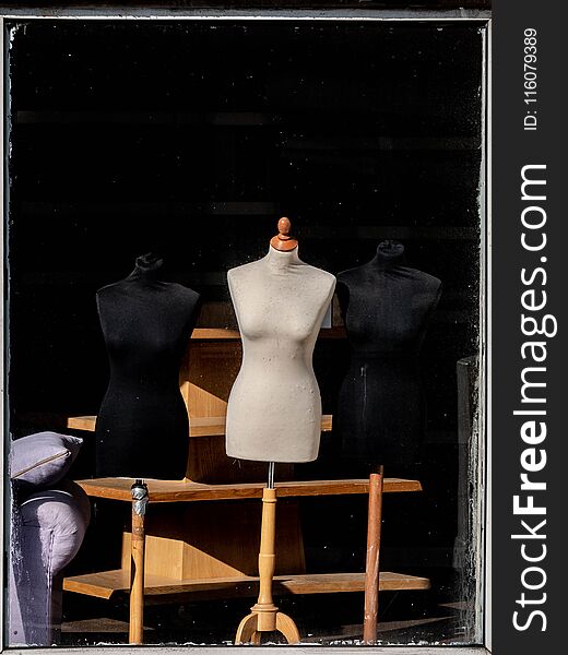 Window display of female mannequins on wooden stands