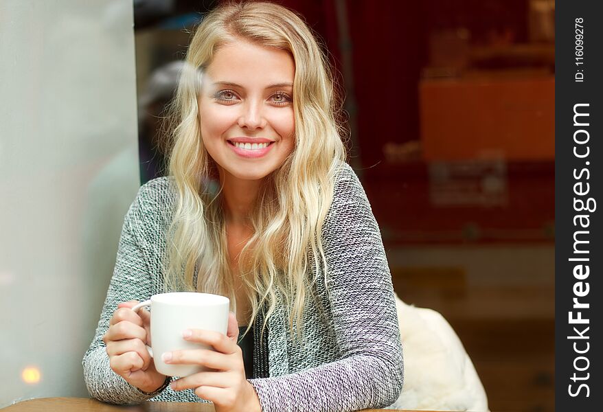 Portrait of a happy relaxed blond having coffee.