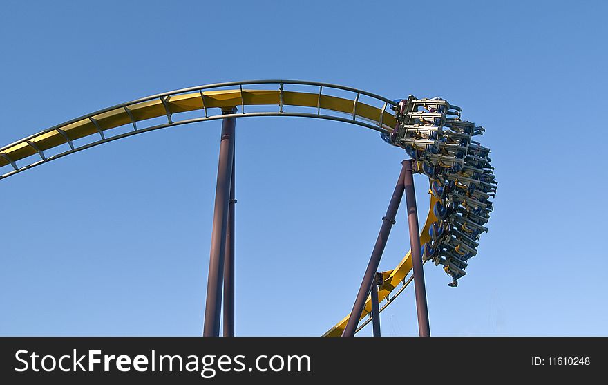 Roller coaster in motion with blue sky in the background. Roller coaster in motion with blue sky in the background