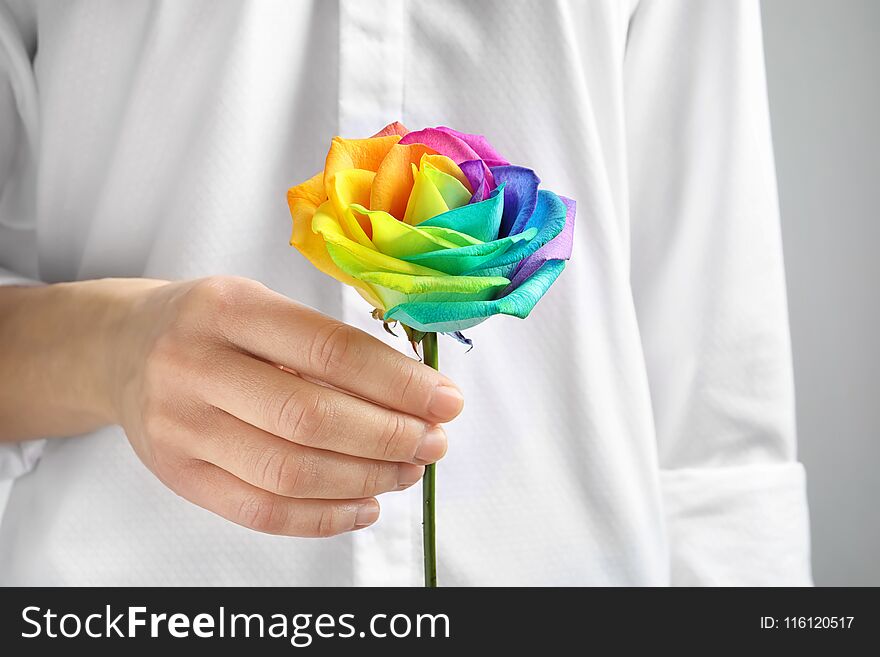 Woman holding rainbow rose flower, closeup