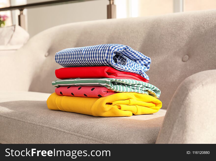 Stack of clothes on sofa in living room