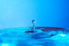 Drop Of Water Falling In Blue Water And Blue Background. Royalty Free Stock Images