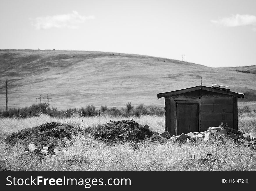 Greyscale Photography of Brown Shed Near Mountain