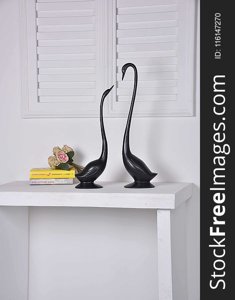 Two Black Geese Figurines on White Console Table