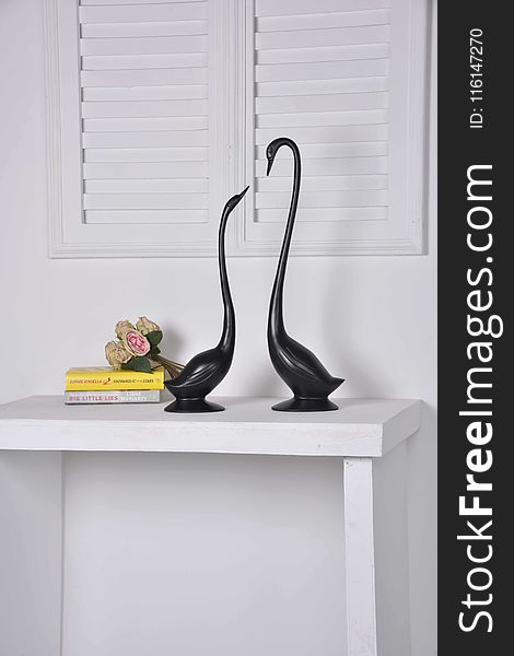 Two Black Geese Figurines On White Console Table