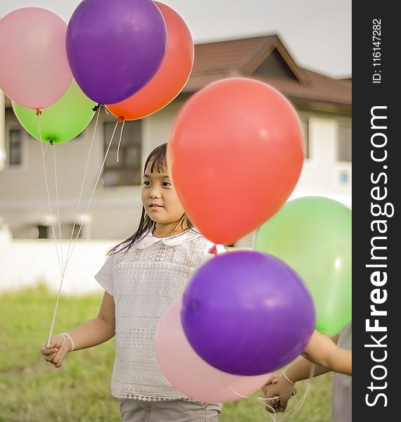 Photography Of A Girl Holding Balloons