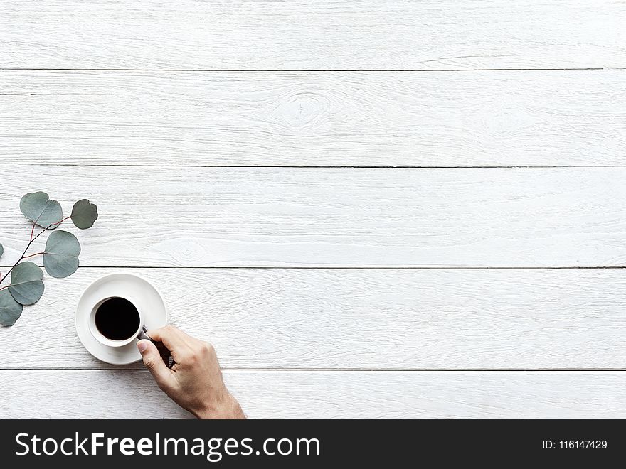Person Holding White Ceramic Teacup With Black Coffee