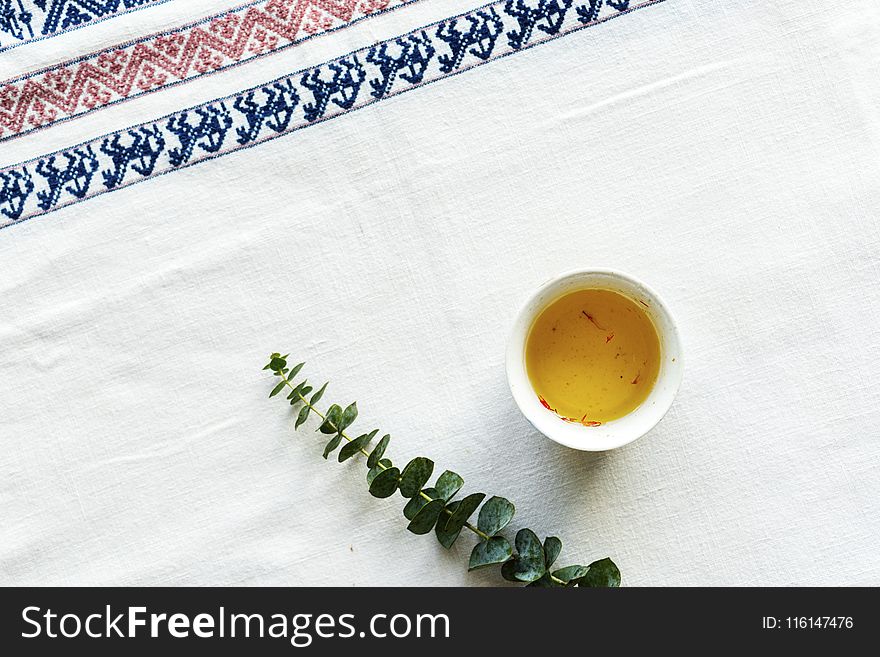 Green Leafed Plant Beside Sauce on White Table Mat