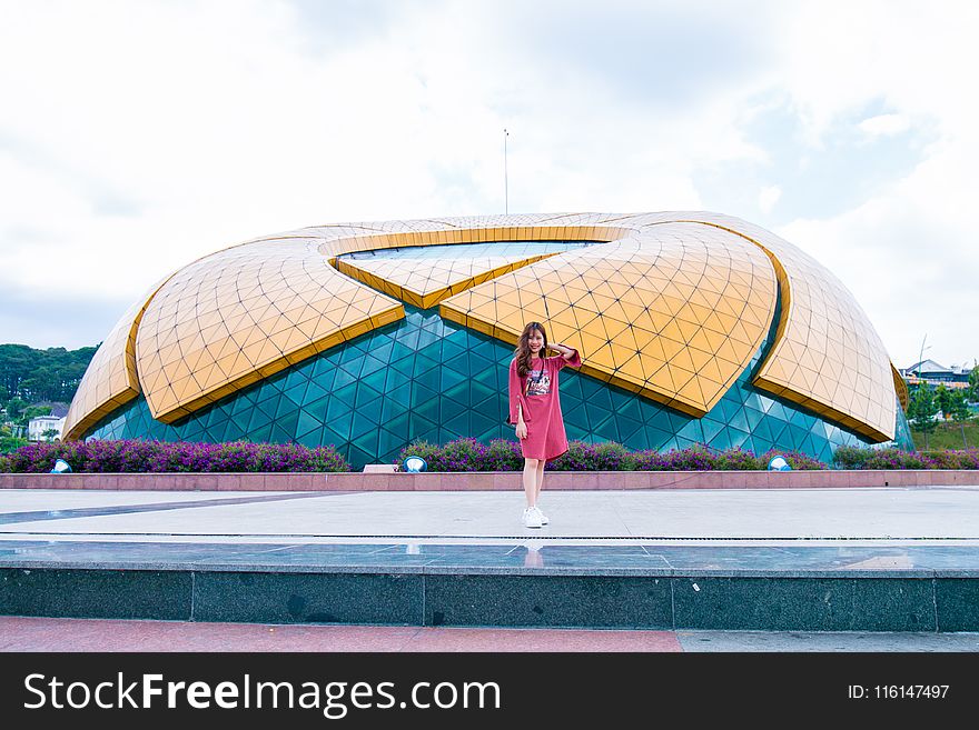 Woman In Red Dress Standing Near Stadium