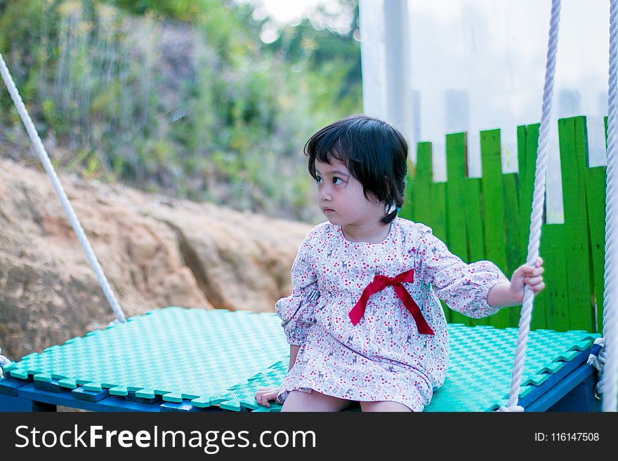 Girl Wearing White Long-sleeved Dress While Sitting On Swing