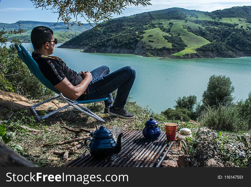 Man Sitting Overlooking Lake