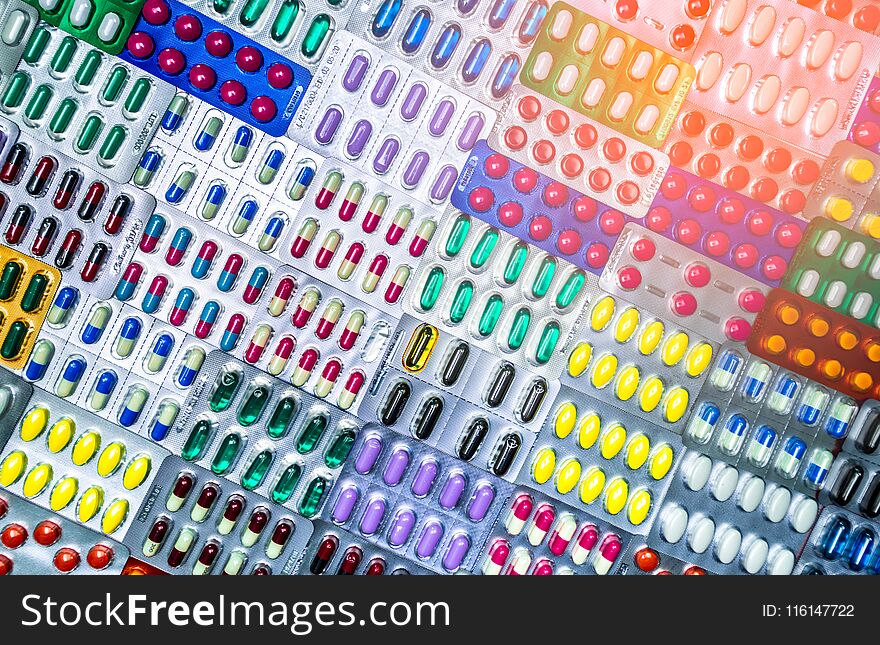 Colorful of tablets and capsules pill in blister packaging arranged with beautiful pattern with flare light. Pharmaceutical