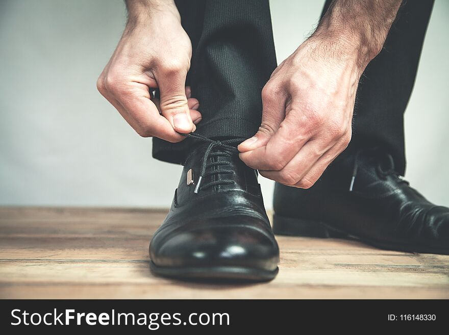 Man tying black leather shoes. Business concept