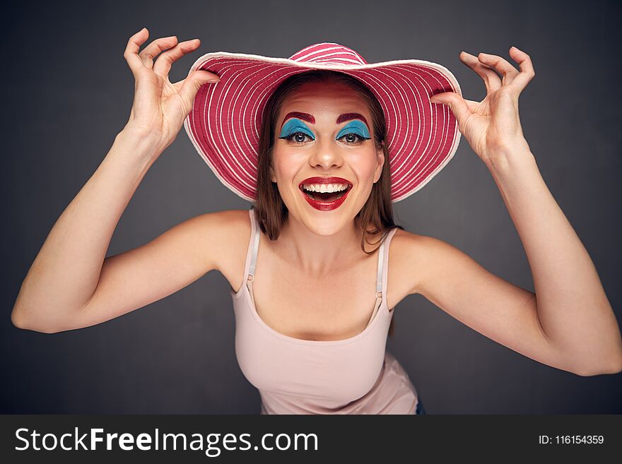 Crazy beauty fashion portrait of woman wearing red summer hat.