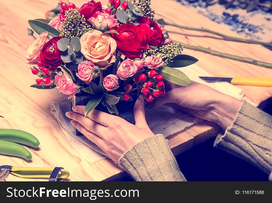 Florist at work makes the arrangement of flowers and eucalyptus in the sponge. toned. Florist at work makes the arrangement of flowers and eucalyptus in the sponge. toned