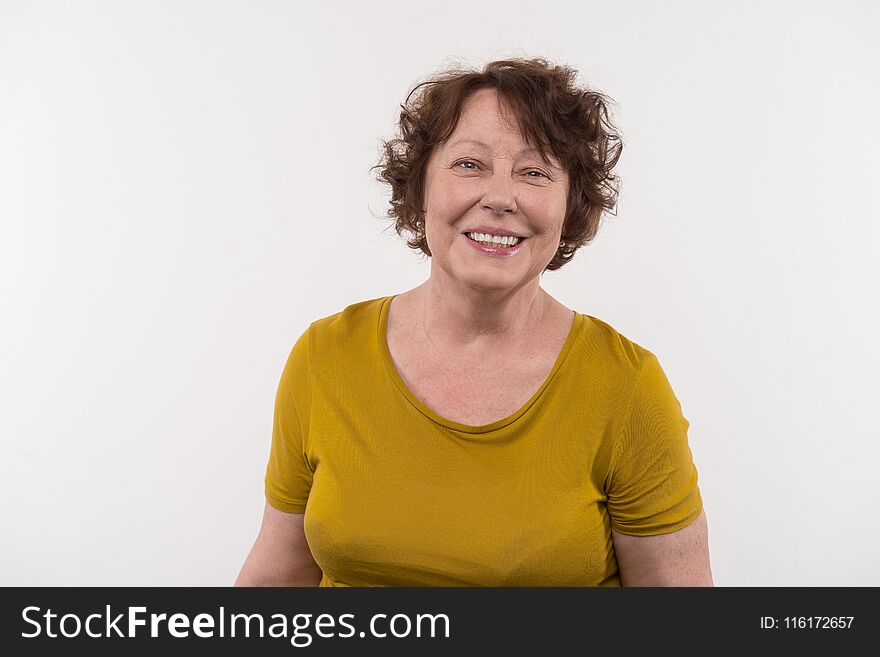 Mature age. Cheerful elderly woman smiling while looking at you