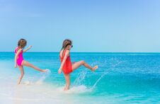 Free Little Happy Girls Splashing. Kids Running To The Turquoise Water Ready To Swim Stock Images - 116199204