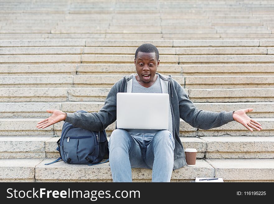 Desperate student sitting on stairs with laptop