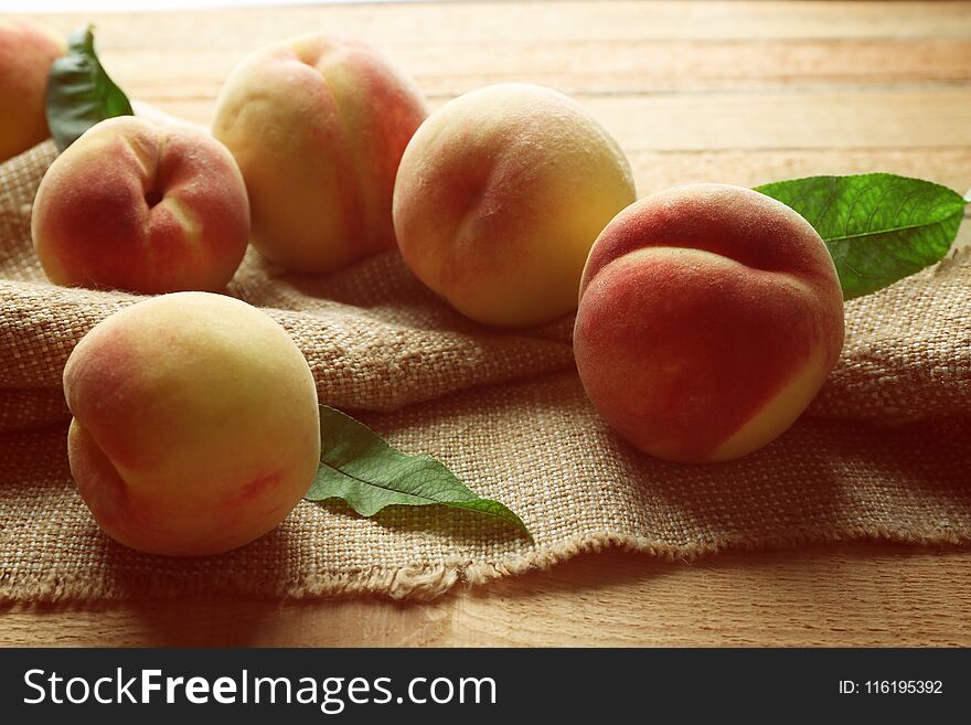 Fresh juicy peaches on bagging and wooden background