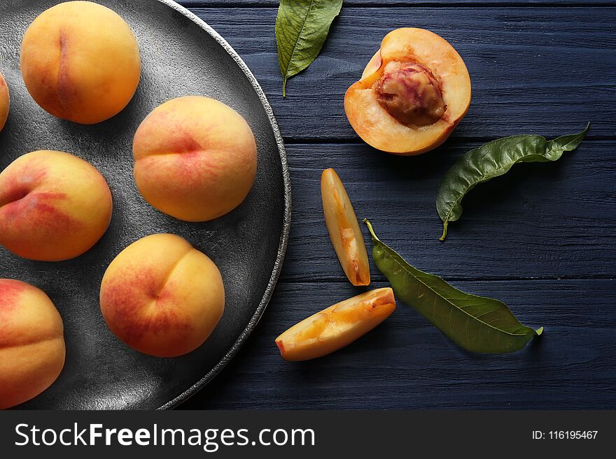 Fresh juicy peaches in tray on blue wooden background