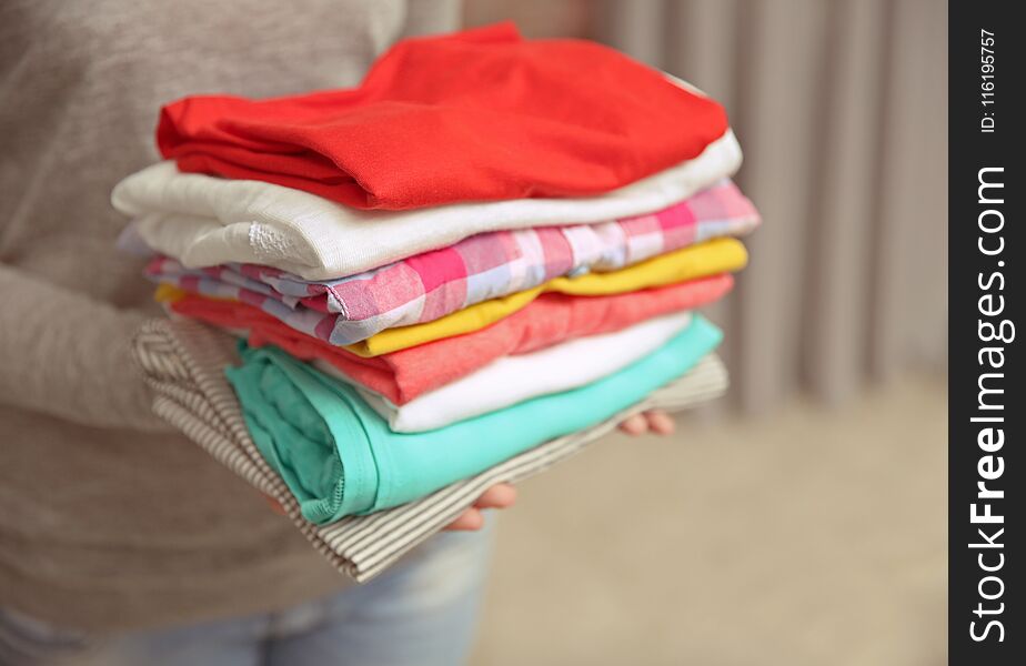 Woman holding pile of clothes, closeup