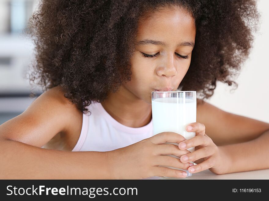 Curly African-American girl drinking milk