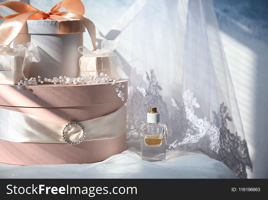 Gift boxes, perfume and bridal veil on white chair