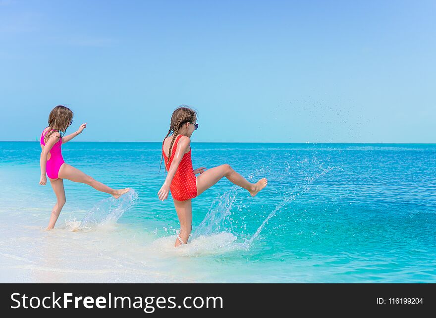 Little happy girls splashing. Kids running to the turquoise water ready to swim