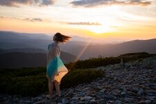 Romantic Woman In A Scarf Stands On The Top During Sunset Stock Photo