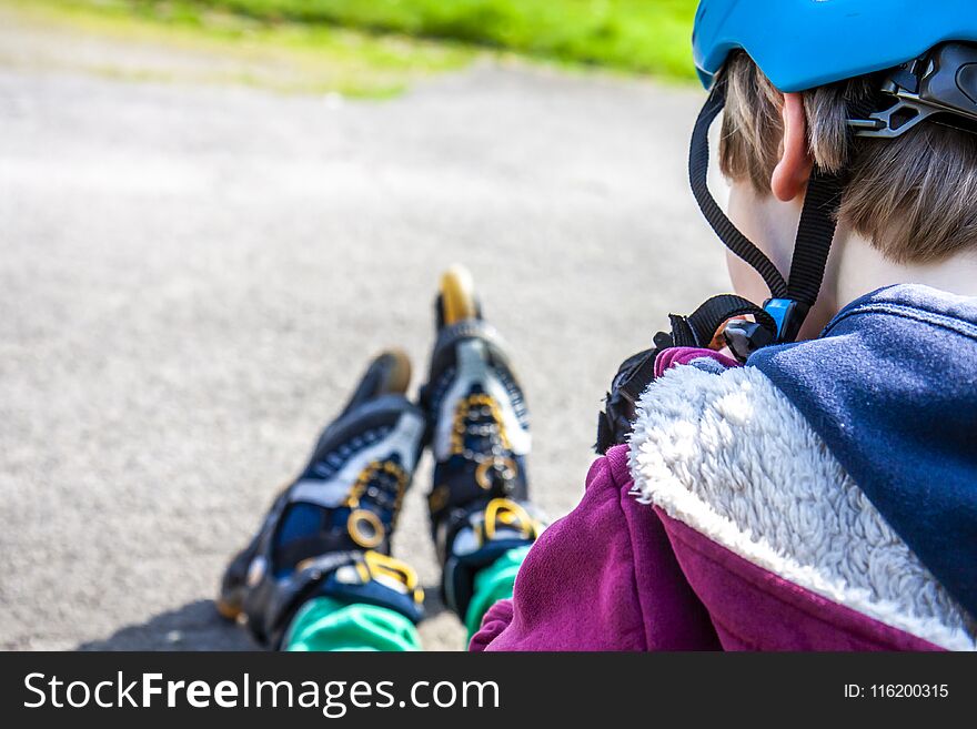 Little Boy Wearing Roller-blades Sitting And Eating And Drinking Mineral Water