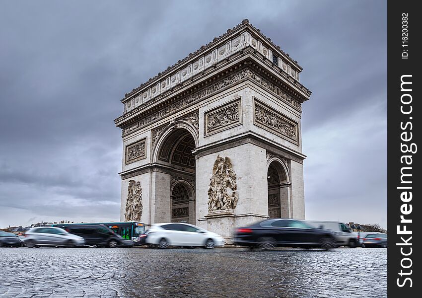 Triumphal arch. Arc de triomphe. View of Place Charles de Gaulle. Famous touristic architecture landmark in rainy day. Long expos