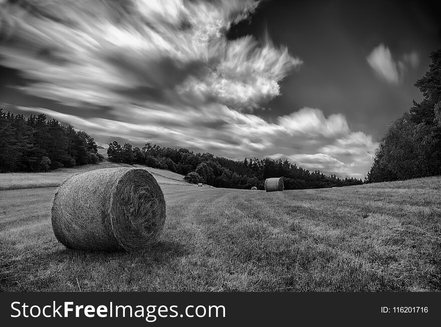 Race of clouds on meadow with parcel