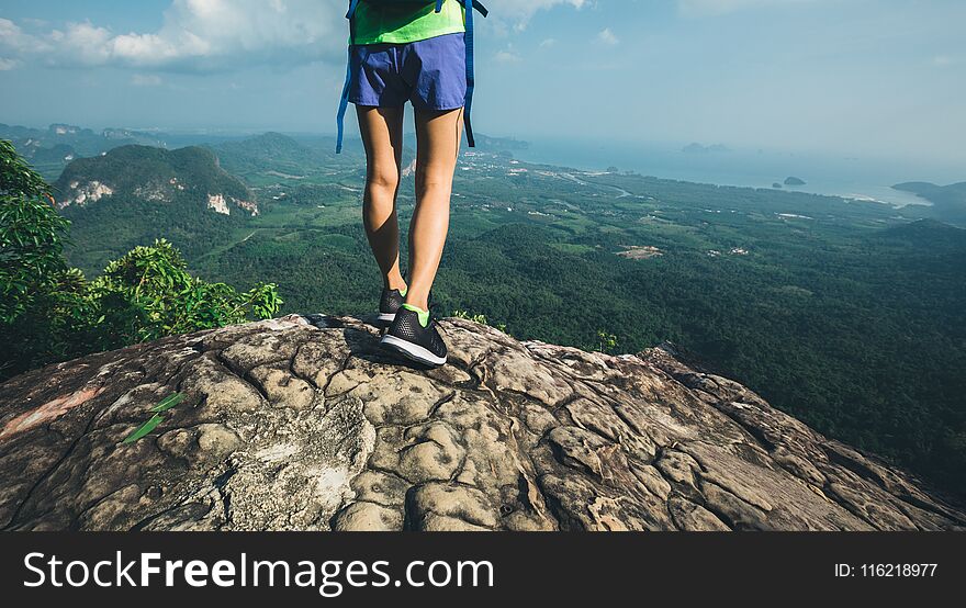 Woman hiker stand on mountain peak cliff edge