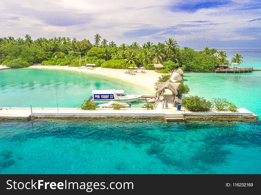 Aerial Photography of White Dock by the Ocean Surrounded With Trees Under Blue Sky and White Clouds