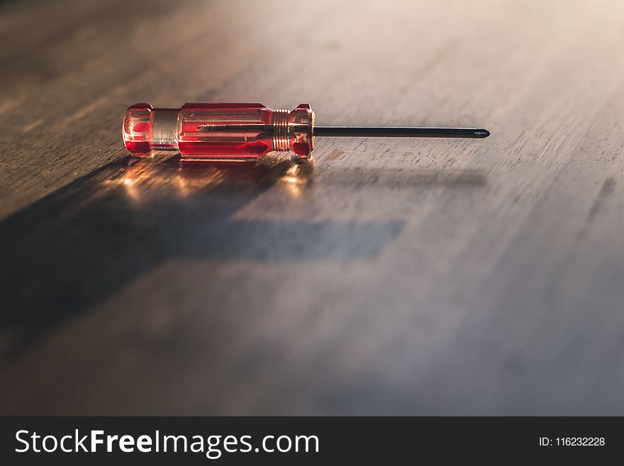 Red Driver on Brown Wooden Surface