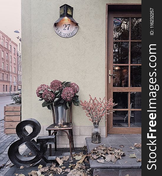 Maroon Flower Bouquet Under Black and White Wall-mount Light Mounted on Beige Concrete Wall