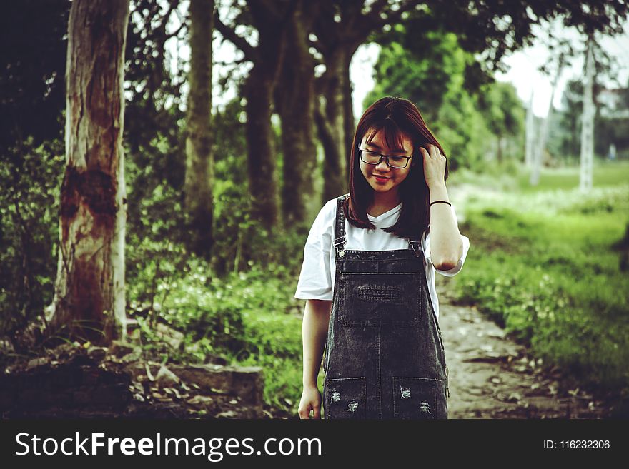 Woman Wearing White V-neck T-shirt and Black Denim Dungaree Standing Beside Trees