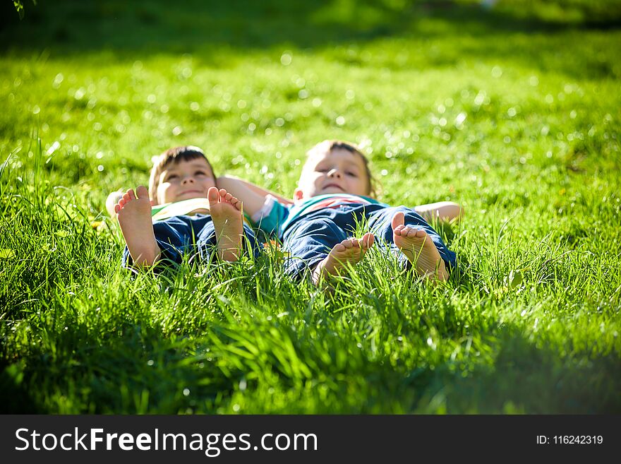 Children laying on grass. Family picnic in spring park. Image of several legs lying on the grass and resting. Relaxation happy childhood friendship concept.