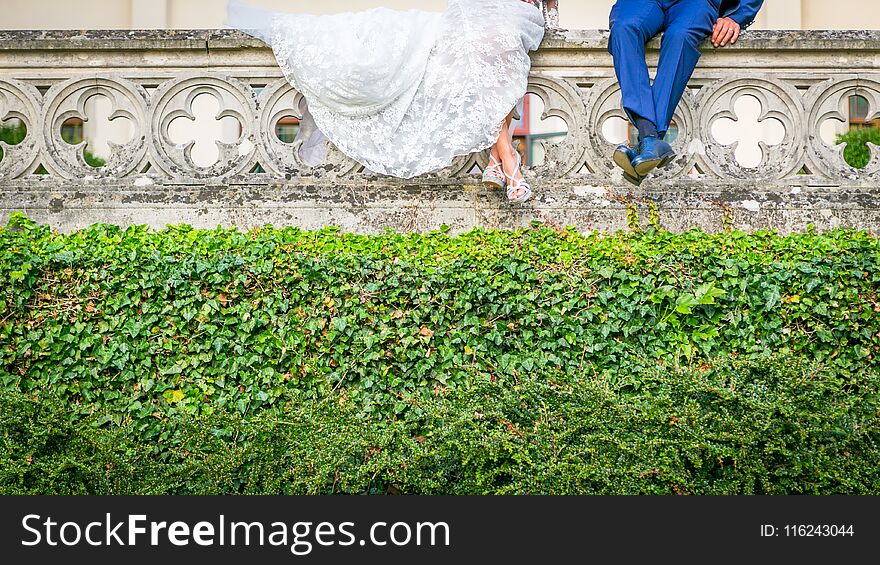 Portrait bride and groom legs, close up your shoes and dress