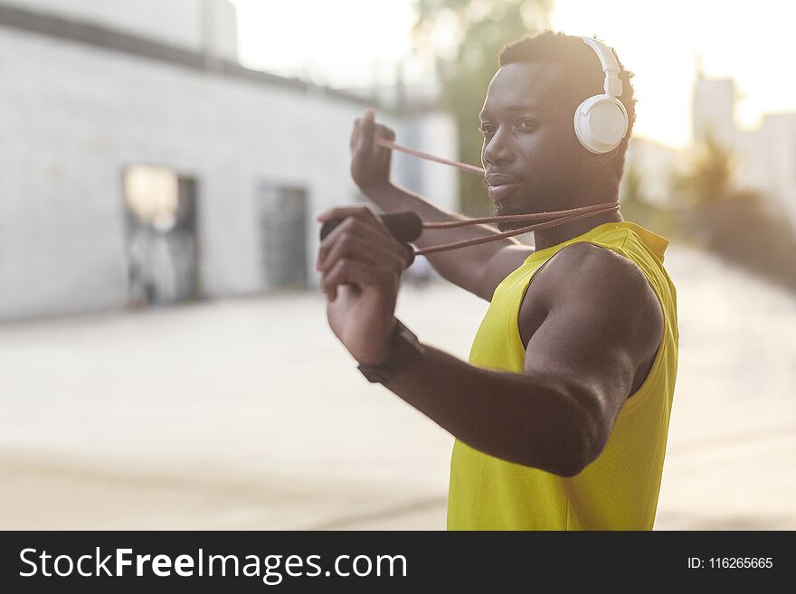 Portrait of handsome sporty afro man holding jump rope. Outdoor shot. Spring morning shot