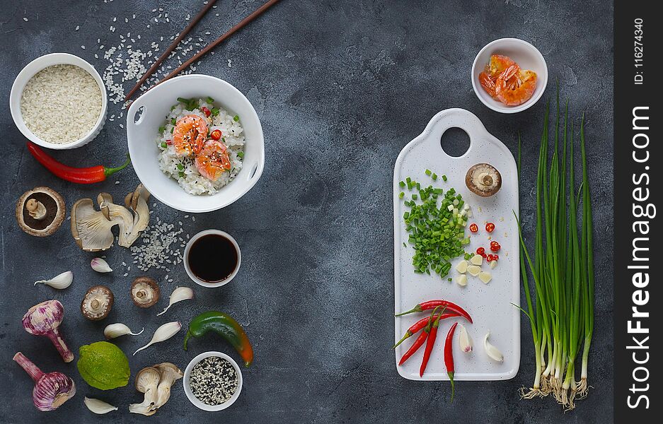 Asian food on a dark background, Wok rice with shrimps and mushrooms, During preparation, Top view, Flatlay