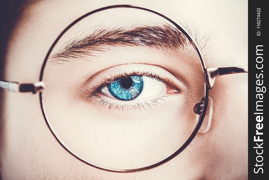 Portrait of a boy wearing eyeglasses blue eyes close, macro studio shot.