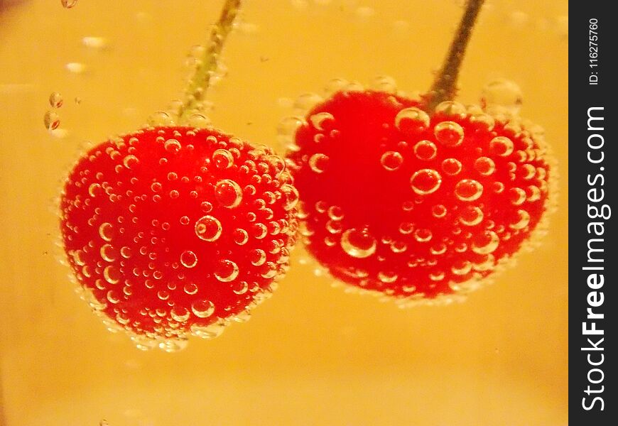 Red cherry in water and bubbles