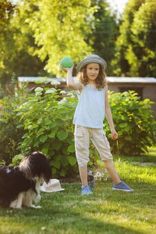 Happy Child Girl Playing With Her Spaniel Dog And Throwing Ball Royalty Free Stock Image