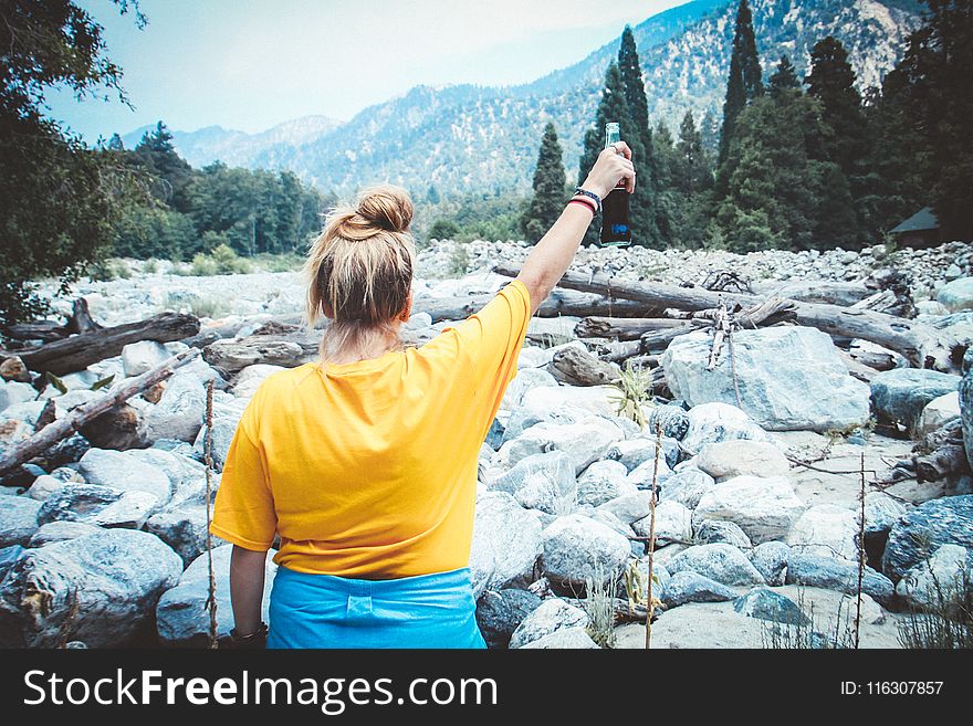 Woman in Yellow Shirt Holding Cola Bottle