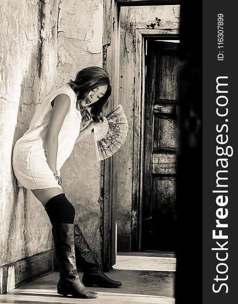 Grayscale Photography of Woman Leaning on Wall